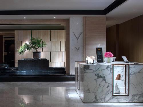 a lobby of a hotel with a potted plant at Sofitel Foshan Shunde in Shunde