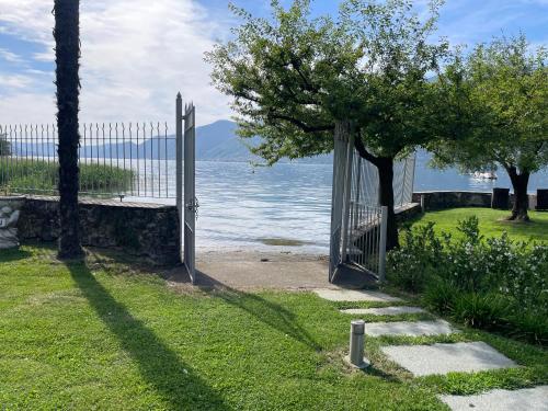 an open gate in the grass near the water at Villa Franca in Pilzone