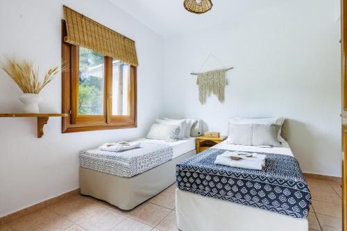 a room with two beds and a window at Casa Gaia in Panormos Skopelos
