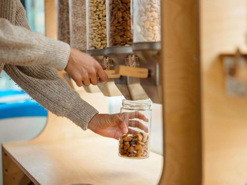 a person holding a jar of nuts in a machine at Mercure Thame Lambert Hotel in Chinnor