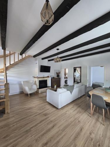 a living room with a white couch and a table at Casă chic La Han la Slănic in Slănic-Moldova