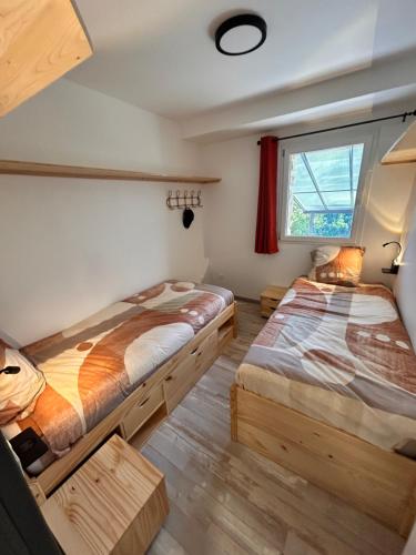 two beds in a room with a window at Gite Les Oliviers d'Ardèche in Chalencon