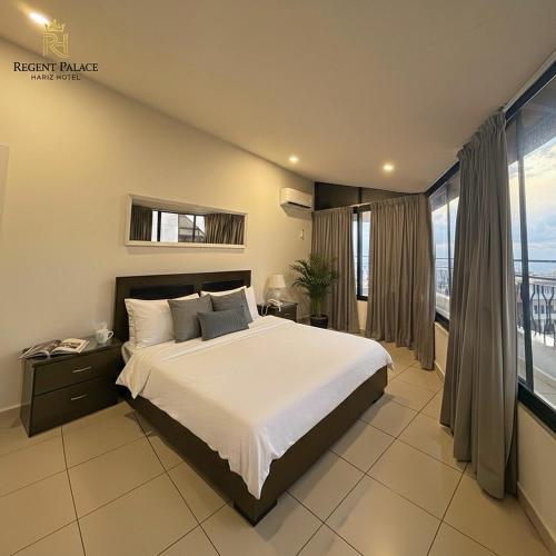 a bedroom with a large bed and a large window at Regent Palace Hariz Hotel in Aley