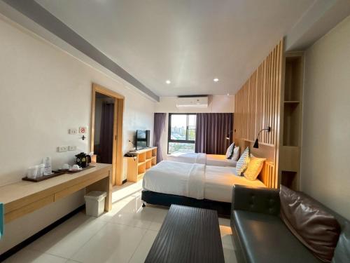 a hotel room with a bed and a couch at Bangkok Boutique Hotel Future Park Rangsit in Pathum Thani