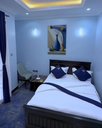 a bedroom with blue walls and a bed with blue pillows at Mignon Hotel - Kalule in Kalule