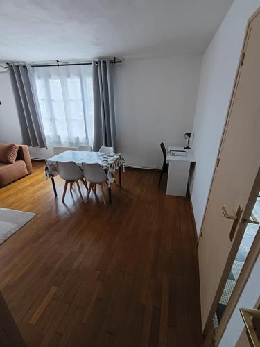 a living room with a table and chairs at Au cœur de Givet in Givet