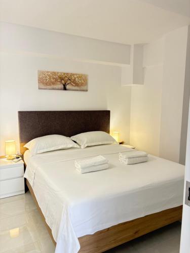 a bedroom with a large white bed with two towels on it at evaxila papaflessa 机场附近 in Glyka Nera