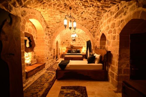 ein Schlafzimmer mit einem Bett in einem Steinzimmer in der Unterkunft Sultan Konağı Hotel - Heritage Stay in Mardin