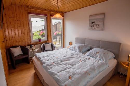 a bedroom with a bed and a chair and a window at Ferienwohnung Schwalbennest in Lennestadt
