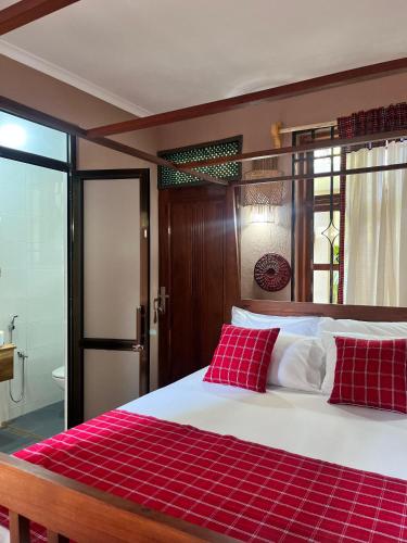 a bedroom with a large bed with red pillows at Marini Ndoto in Themi