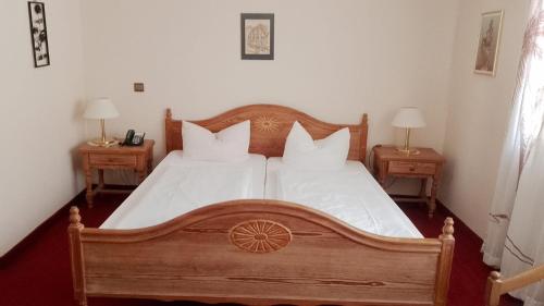 ein Schlafzimmer mit einem Holzbett und zwei Nachttischen in der Unterkunft Hotel & Gasthof Resengörg in Ebermannstadt