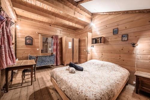a bedroom with a bed in a wooden room at Chalet Familial Chaleureux in Abondance