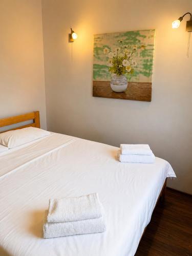 two beds in a room with towels and a painting at Sunny House Seaside in Zatoka