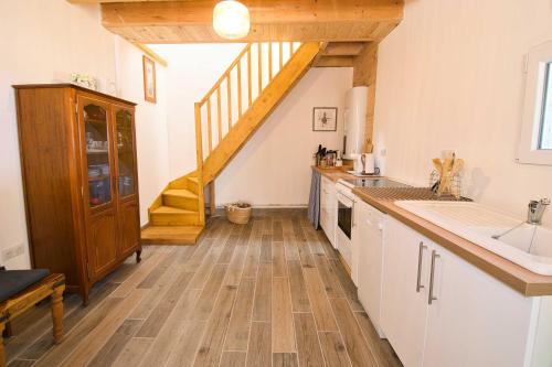 a kitchen with a wooden floor and a staircase at The Lodge Gite 3 Star in Saint-Privat-des-Prés