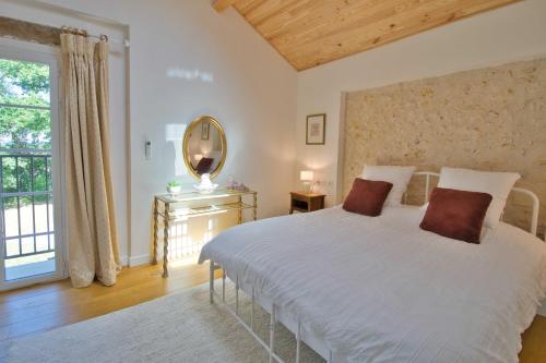 a bedroom with a bed with a mirror and a window at The Lodge Gite 3 Star in Saint-Privat-des-Prés