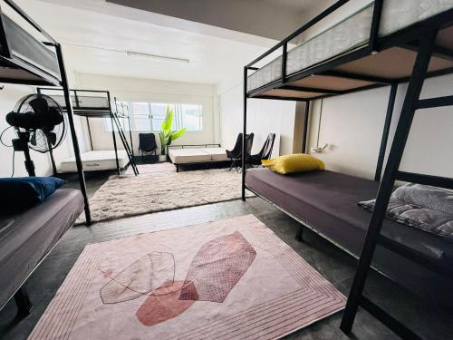 a bedroom with two bunk beds and a living room at Hee Pee hostel Buriram in Sathani Buriram