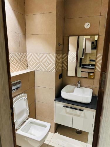 a bathroom with a sink and a toilet and a mirror at Stay Karo Yaar in Ghaziabad
