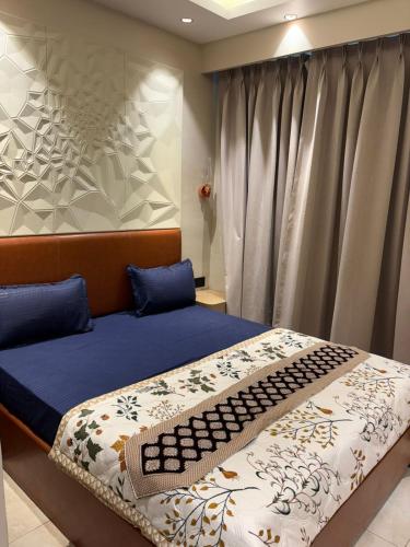a bedroom with a bed with blue pillows at Stay Karo Yaar in Ghaziabad