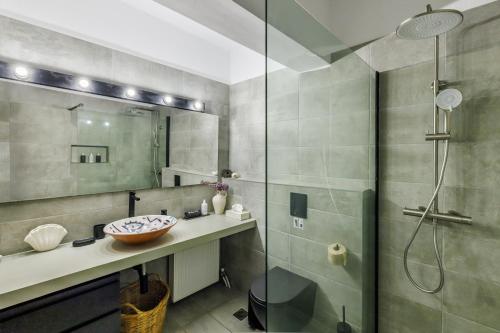 a bathroom with a sink and a glass shower at Casa Naturale in Skopelos Town