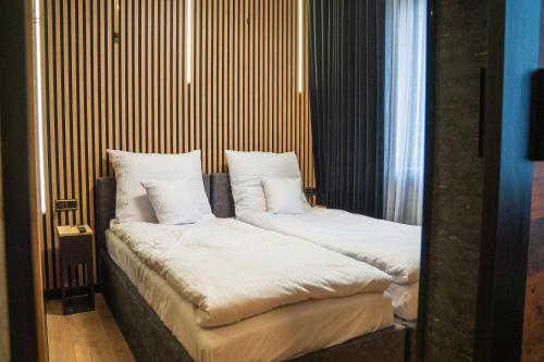 two beds with white pillows in a room at Kaszmir Apartments in Opole