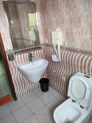 a bathroom with a white toilet and a sink at Résidence New Land Sarl in Douala