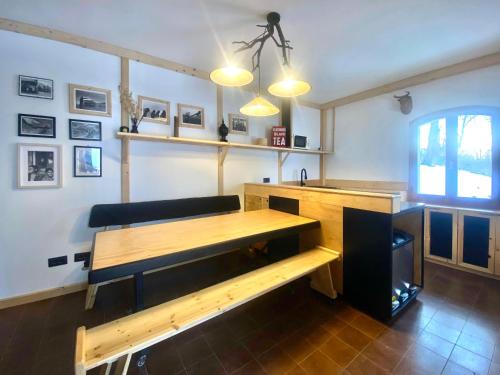 a room with a wooden table and a bench at Shangri-La Travellers' Hostel in Castel dellʼAlpi
