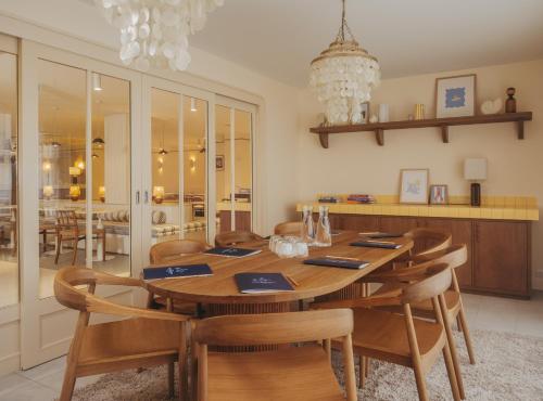 a dining room with a wooden table and chairs at Hotel Coeur Marin in Les Sables-d'Olonne