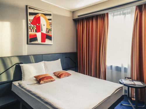 a bedroom with a bed with two pillows on it at Mercure Kyiv Congress in Kyiv