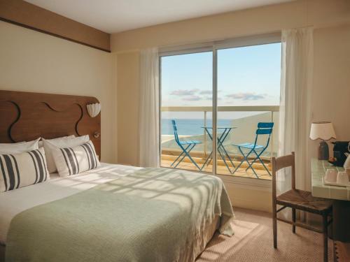 a bedroom with a bed and a view of the ocean at Hotel Coeur Marin in Les Sables-d'Olonne