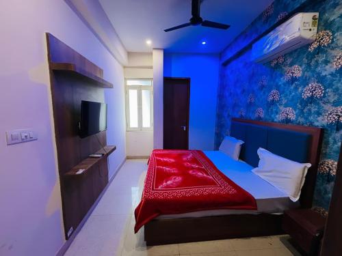 a blue bedroom with a bed with a red blanket at Hotel Meera in Bāwal
