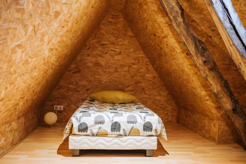 a bedroom with a bed in an attic at Le nid du Randonneur in Marmanhac