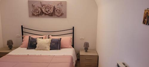 a bedroom with a bed with pink and black pillows at LA CASA DI SIRA in Veiano