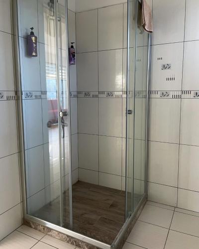 a shower with glass doors in a bathroom at Rix Palm Apartments in Kyrenia
