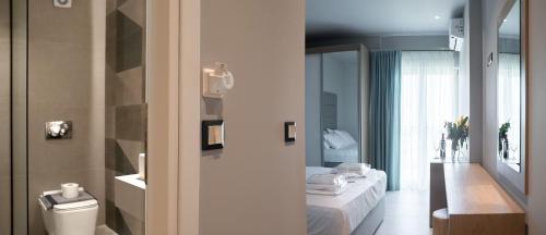 a bathroom with a bed and a toilet in a room at Tresor Sousouras in Hanioti
