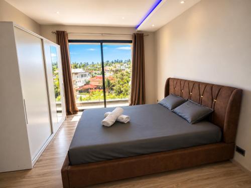 a bedroom with a bed with a large window at Oaks Penthouse - Flic en Flac in Flic-en-Flac