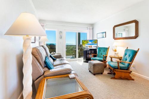 a living room with a couch and a table with a mirror at AV2D - By The Sea in Nags Head