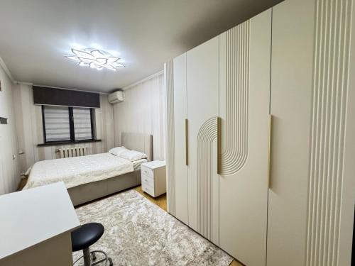 a small bedroom with a bed and a desk at Apartment in Almaty