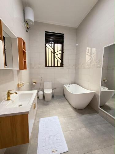 a bathroom with two sinks and a tub and a toilet at The Serene Sanctuary in Kampala
