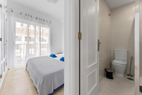 a white bedroom with a bed and a toilet at Edf España Suites Mijas in Mijas
