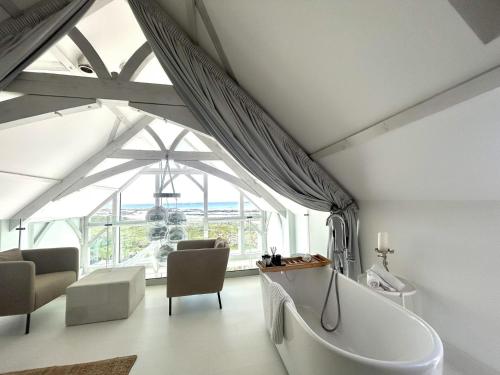 a bathroom with a tub and a large window at Doleen Quay House in Ballyconneely