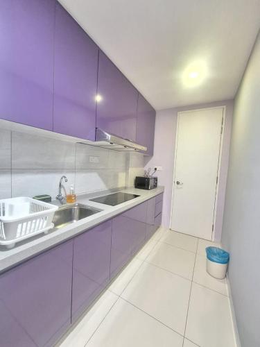 a kitchen with purple cabinets and a sink at Robertson Luxury Apartment in Kuala Lumpur