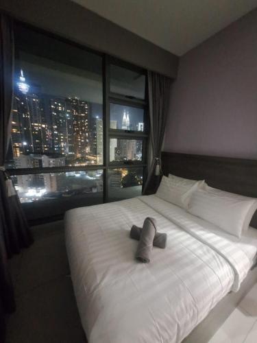 a bedroom with a large white bed with a window at Robertson Luxury Apartment in Kuala Lumpur