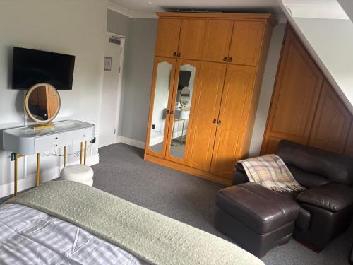 a bedroom with a bed and a chair and a cabinet at Ivy Guesthouse in Kilkenny