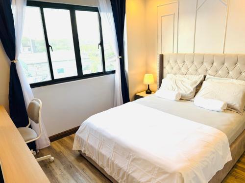 a bedroom with a white bed and a window at Endless Summer Seafront - 1BR Beach Resort Condo in San Juan