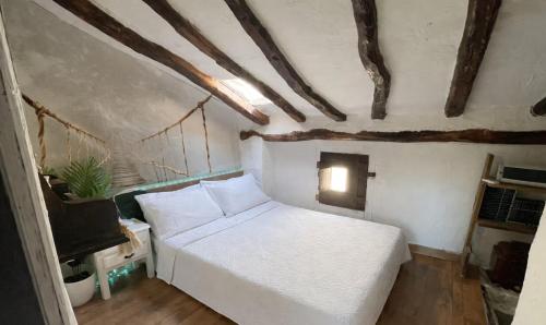 a bedroom with a white bed and a tv at Ca'n Baster 1878 in Juncosa