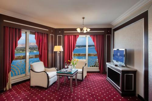 a living room with a television and a room with a view at Sonesta St. George Hotel - Convention Center in Luxor