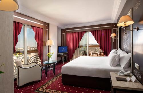 a hotel room with a bed and a balcony at Sonesta St. George Hotel - Convention Center in Luxor