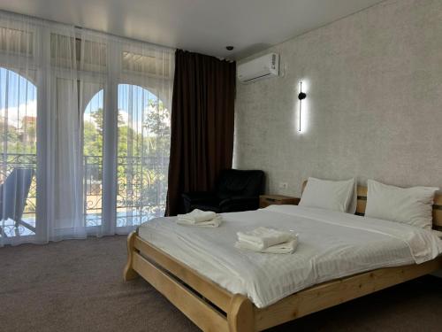 a bedroom with a bed with a chair and a window at Готель River House in Uman