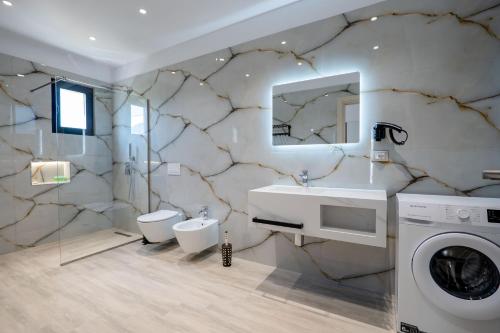 a bathroom with a sink and a washing machine at Hotel Roalb in Vlorë