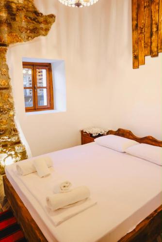 a bedroom with a bed with two towels on it at Stone Villa Berat in Berat